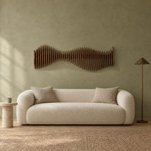Anomaly in walnut stain above a cream bouclé sofa in a sage plaster living room