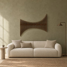 Cadence in walnut stain above a cream bouclé sofa in a sage plaster living room