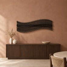 Meander in black stain above a fluted dark-oak sideboard in a terracotta plaster dining room