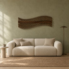 Meander in walnut stain above a cream bouclé sofa in a sage plaster living room