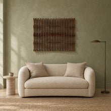 Strata in walnut stain above a cream bouclé loveseat in a sage plaster living room